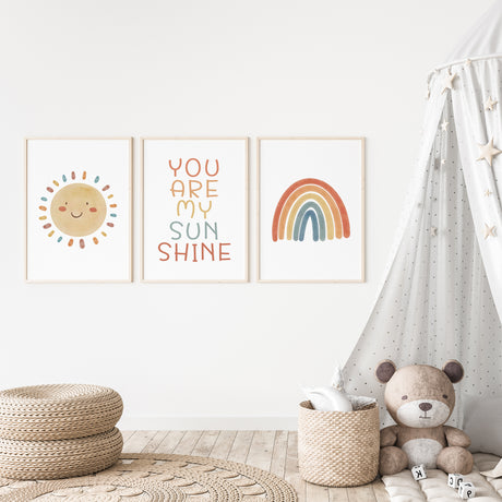 Set of 3 nursery prints featuring sunshine quote, smiling sun, and retro rainbow in bright pastel tones